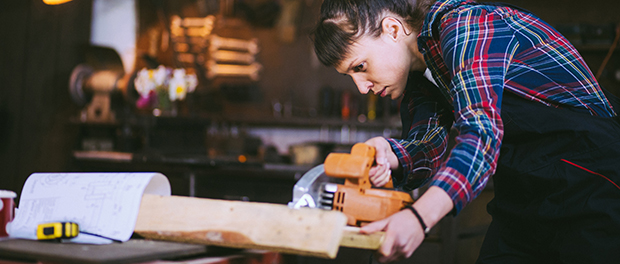 Concentrated Carpenter Girl Cutting Plank With Circular Saw