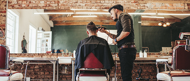 Hairstylist serving client at barber shop