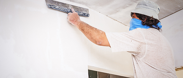 manual worker with wall plastering tools