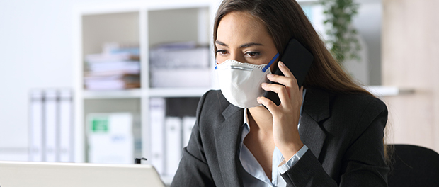 Pensive executive calling on phone avoiding coronavirus at office