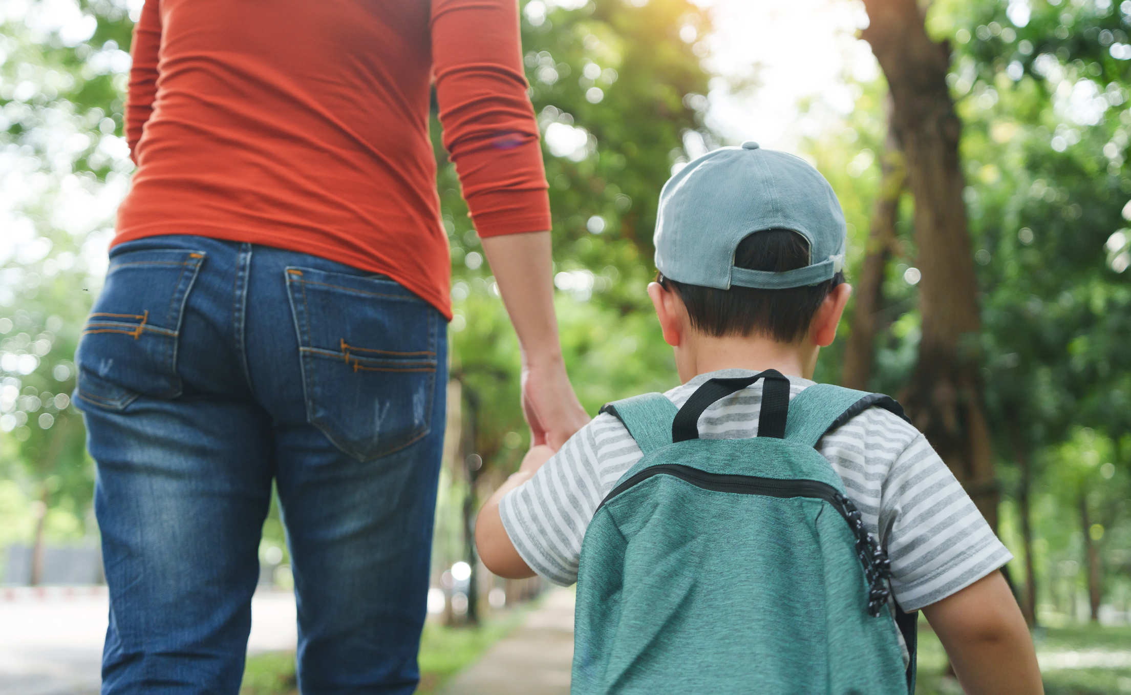 Mamá besando a sus hijos en el parque