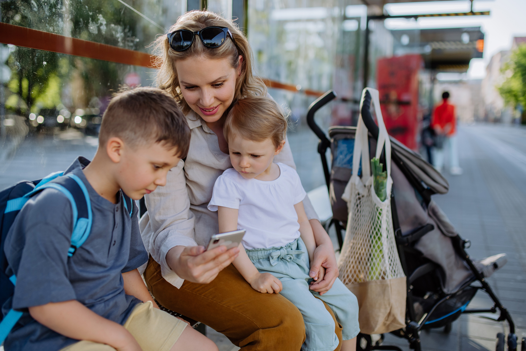 Madre con hijos esperando el autobús