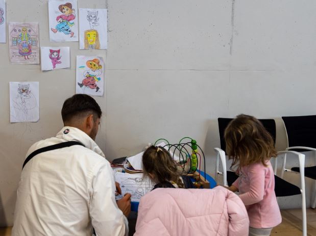 Niñas pintando en un cuaderno con su padre