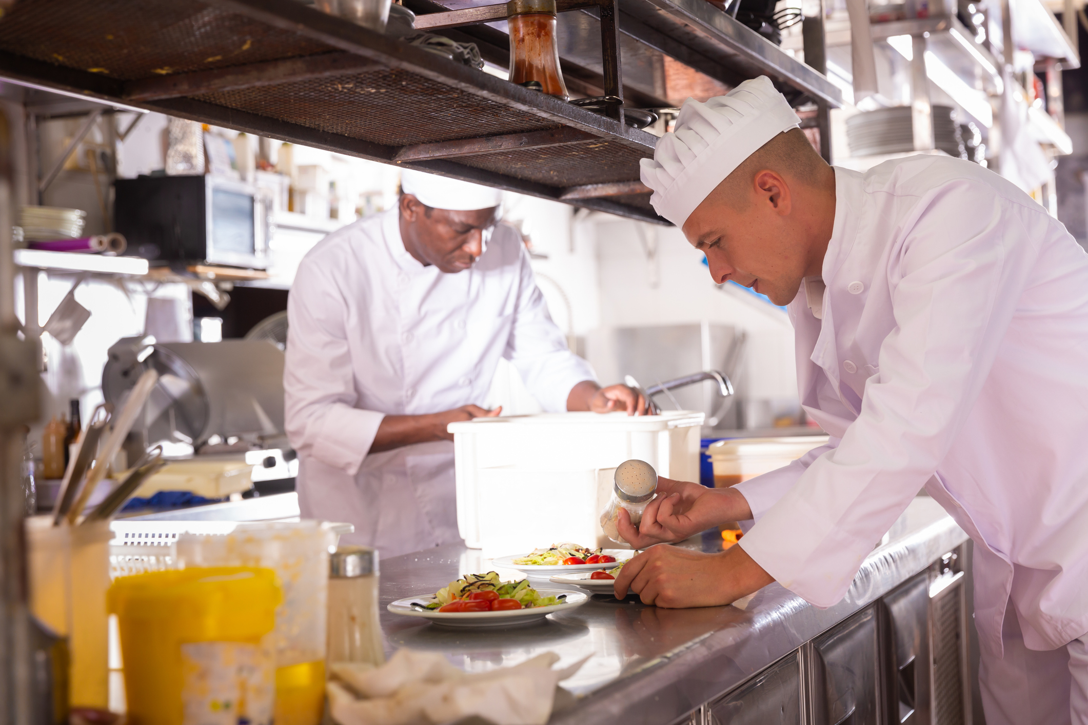 Personas extranjeras trabajando de cocineros en un restaurante español