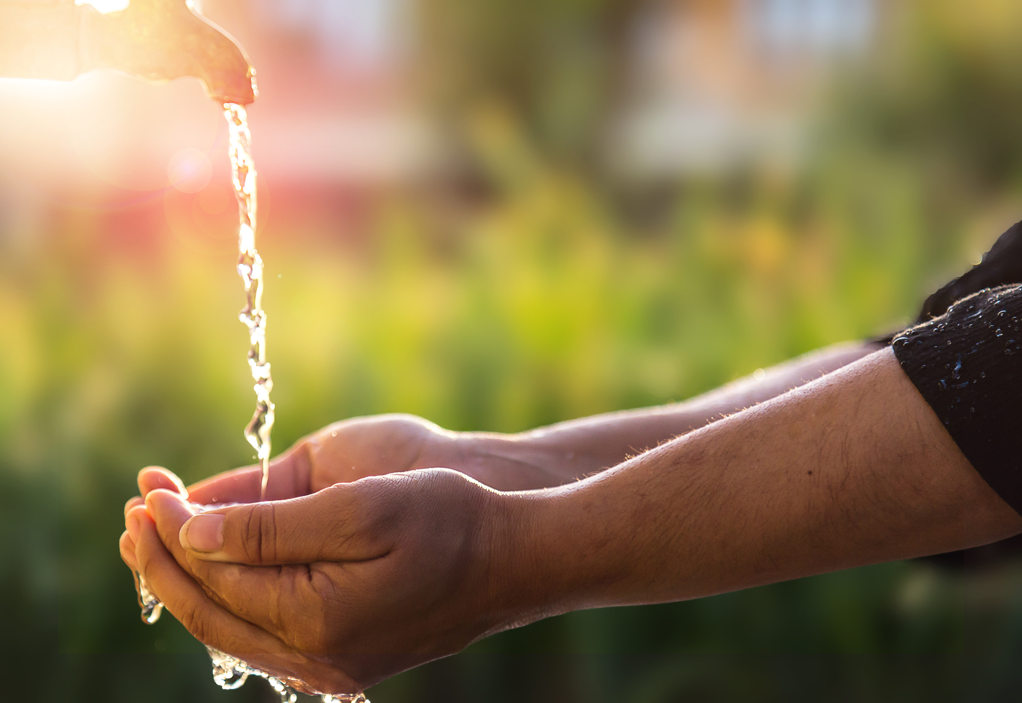 Manos entrelazadas bajo el agua de una fuente